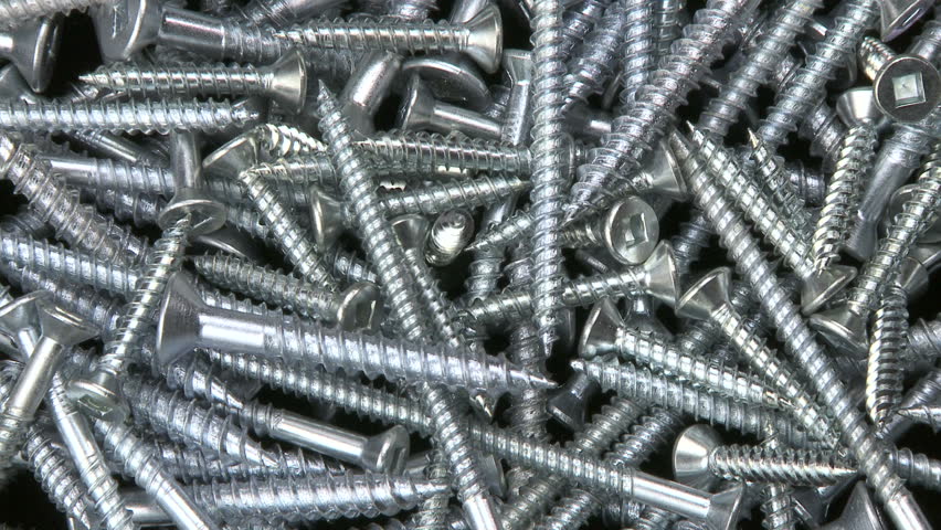 Close up counter clockwise rotation on a pile of hardware screws