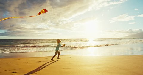 Young boy playing with kite on the beach