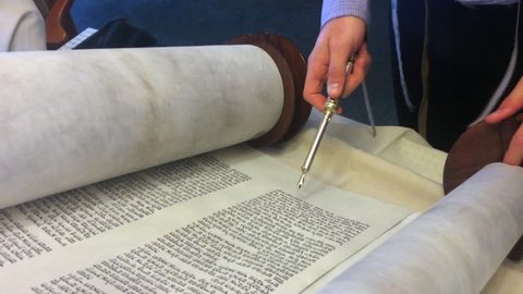 AUCKLAND - AUG 04 2016:Jewish rabbi read Torah.Traditionally the words of the Torah are written on a scroll by a sofer on parchment in Hebrew. Reading the Torah is one of the bases for Jewish life.