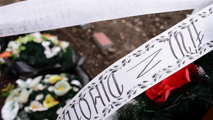 Grave with wooden cross with flowers and wreaths in memory of the deceased filed recently 2b (Write on white paper: SON / DIMOFTE)
