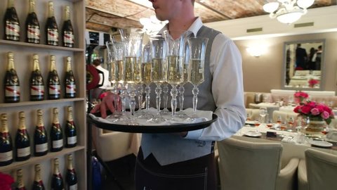 steadicam video of waiter and champagne glasses on a tray