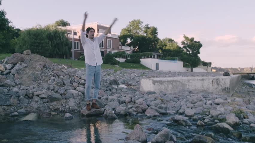 Alone rich man walk at the sea and waiting for friends which should arrive on the yacht, man in white shirt and jeans, beautiful hair, relax, outdoor portrait