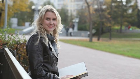 Pretty girl with book smiling at camera