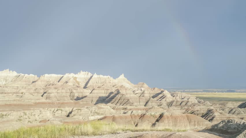 A Rainbow and Dramatic Late Afternoon Clouds Move Across the Amazing Badlands of South Dakota 4K UHD Timelapse