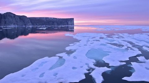 Drifting past sea ice under the midnight sun on Scott Island off Baffin Island in Nunavut, Canada. (Nunavut, Canada 2010s)