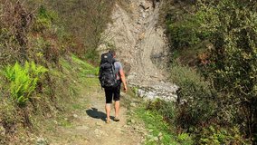 Hiker with backpack walking in mountain valley road. Himalayas Nepal travel nature HD video.