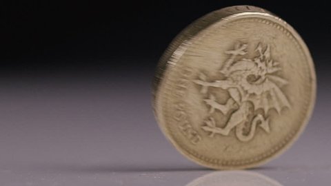 British One pound Sterling coin spinning, in slow motion