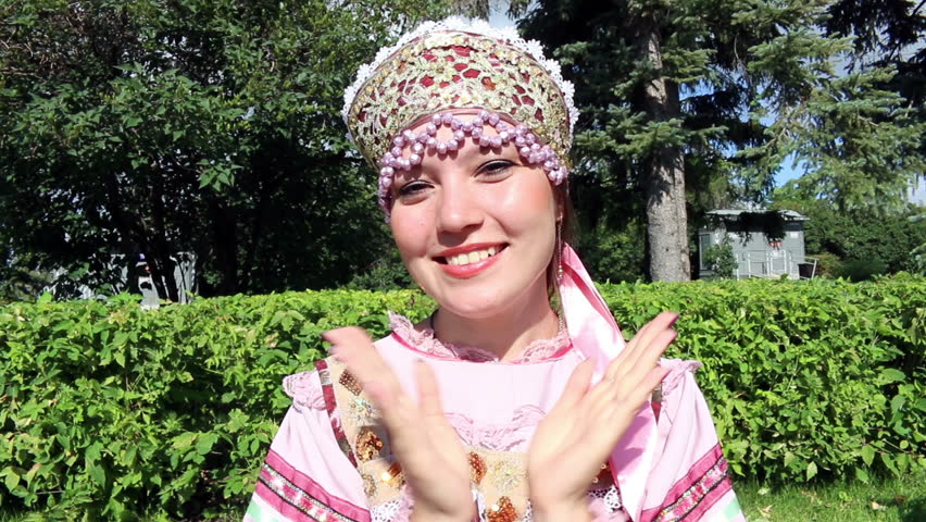 Girl in folk costume applauds