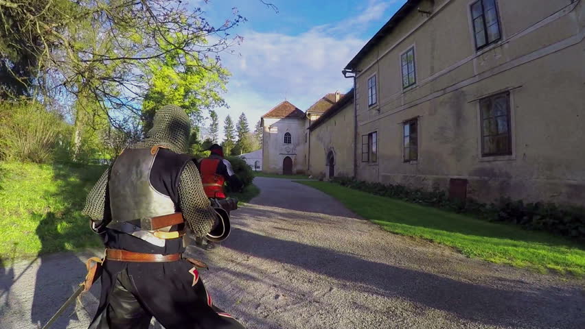 Knights are following another knight. They are running after him and are having swords in their hands. They stop at the castle