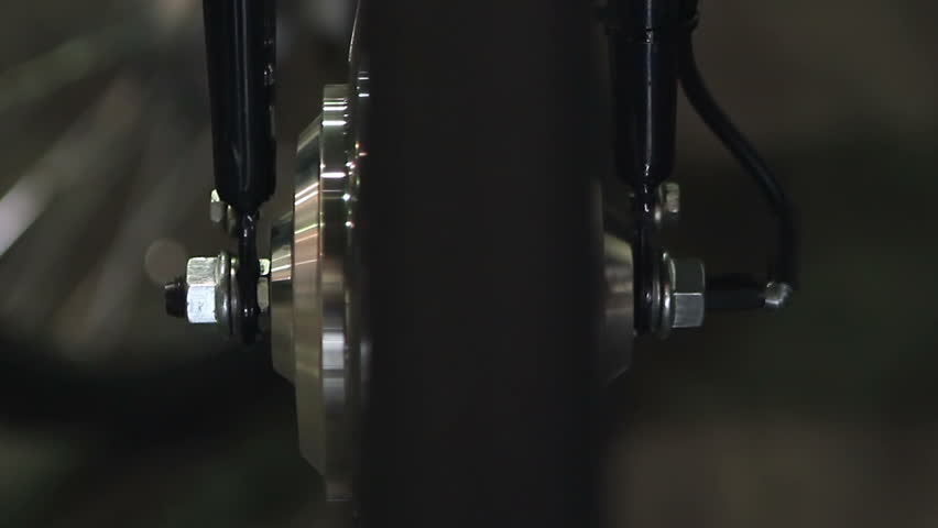Bicycle wheel rotating at workshop, technical maintenance for vehicles, closeup