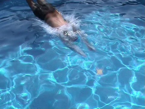 Man jumping and swimming underwater in the pool