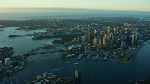 Aerial view at sunrise of Sydney Harbour Bridge and downtown city buildings