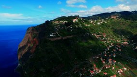 Flight over ocean mountain city Funchal. Portugal Madeira village 4k travel video background. Aerial drone view of coast, buildings, forest hills, seashore