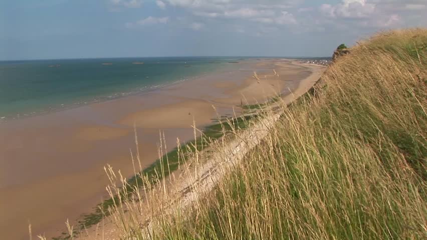 View of Gold beach with Arromanches-les-Bains and Phoenix Blocks in distant background where the Normandy landings took place on D-Day June 6th 1944 in Calvados Department Normandy, France