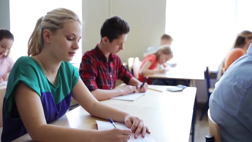 Education, people and learning concept - group of students with notebooks writing test at school | Shutterstock HD Video #18726548