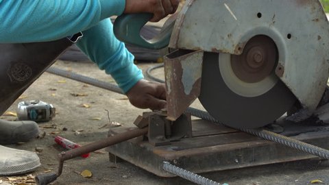 Worker Sawing cut Metal Line With a Circular Saw Sparks on Location building .