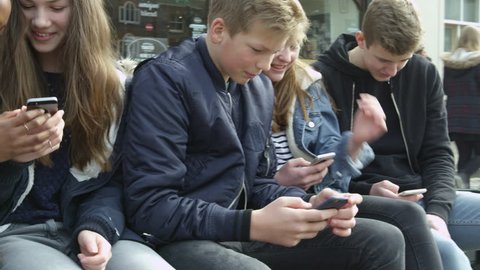 Teenage Friends In Town Using Mobile Phones Shot On R3D