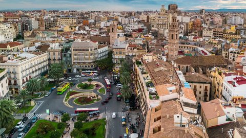 Aerial view of Valencia, Spain at sunset. Illuminated Plaza de la Reina with many cafes and restaurants and very popular among tourists. Cloudy colorful sky. Time-lapse