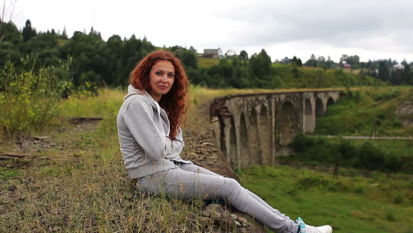 Girl sitting on the old viaduct