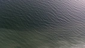 Aerial view footage of sea waves reaching shore. Top view on the beautiful sandy beach from copter.