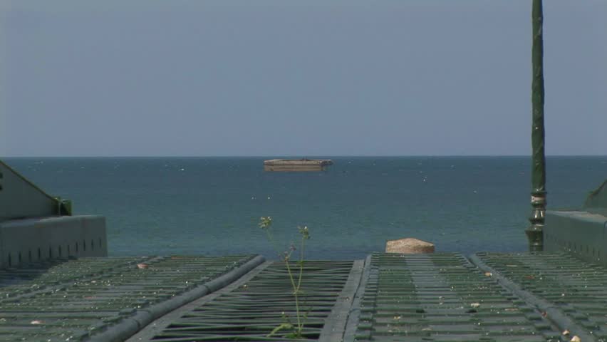 Back zoom from WW2 Mulberry caisson to section of a Mulberry Whale Roadway on Gold Beach Arromanches where the Normandy landings took place on D-Day June 6 1944 in Calvados Department Normandy France