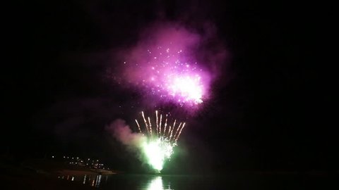 Show with large colorful fireworks in the dark sky. Fireworks on Fiastra lake in the Marche in Italy.