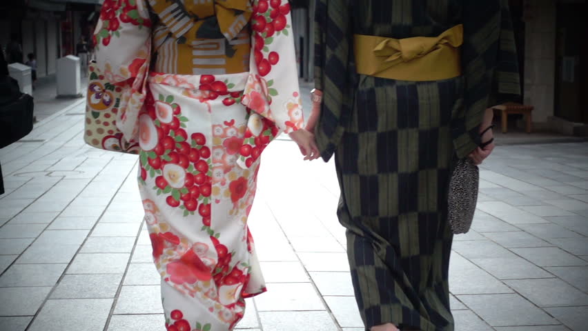 Teenager couple in kimono suits walking on the street, Slow motion