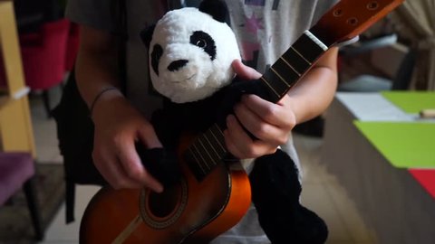 Panda bear plays guitar. toy panda. boy plays with a panda. panda puppet plays guitar. soft toy panda