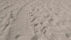 Beach fine sea sand granulation with foot stamps and tire trails 4K 2160p 30fps UltraHD tilting footage - Slow tilt over ocean coast line 3840X2160 UHD video