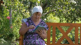 Elderly woman studying web tablet