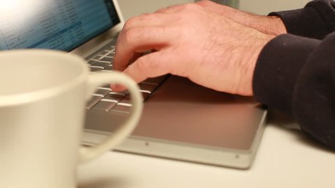 Closeup of man's hand typing on laptop