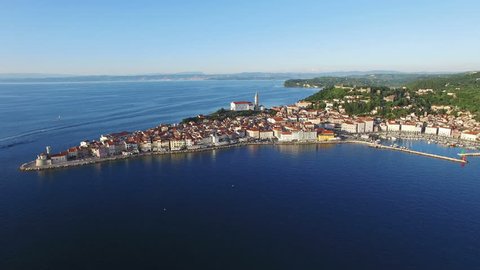Flight over old city Piran in Slovenia, aerial panoramic view with old houses, St. George's Parish Church, Tartini Square, fortress and the sea. 
