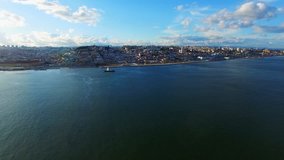Portugal Lisbon 4k video background. Flying aerial city coast panoramic view, Tejo river water, ship sky clouds
