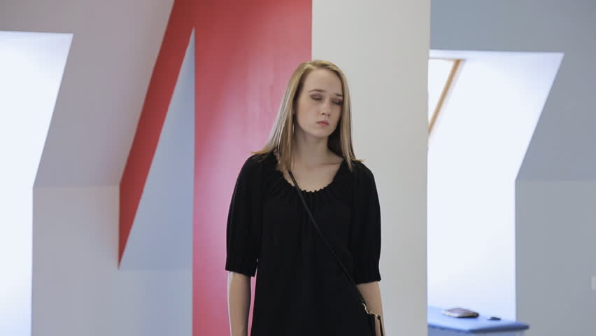 Adorable blonde girl stands in middle of dancing room during lesson.
