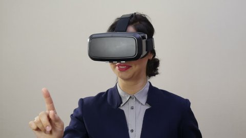 Woman uses a head mounted display. A woman in a virtual reality mask looks around.  स्टॉक वीडियो