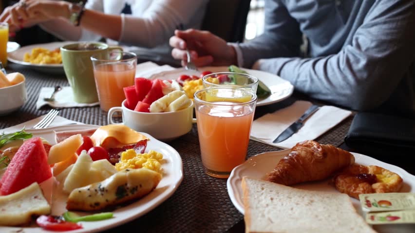 Table with food and glasses of juice, hands of eating people Royalty-Free Stock Footage #18785828