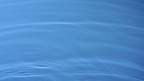 Slo-motion water rippling against blue background