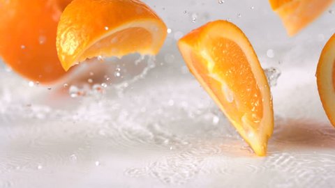 Slo-motion orange falling into wedges