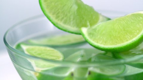 Slo-motion lime wedges into glass