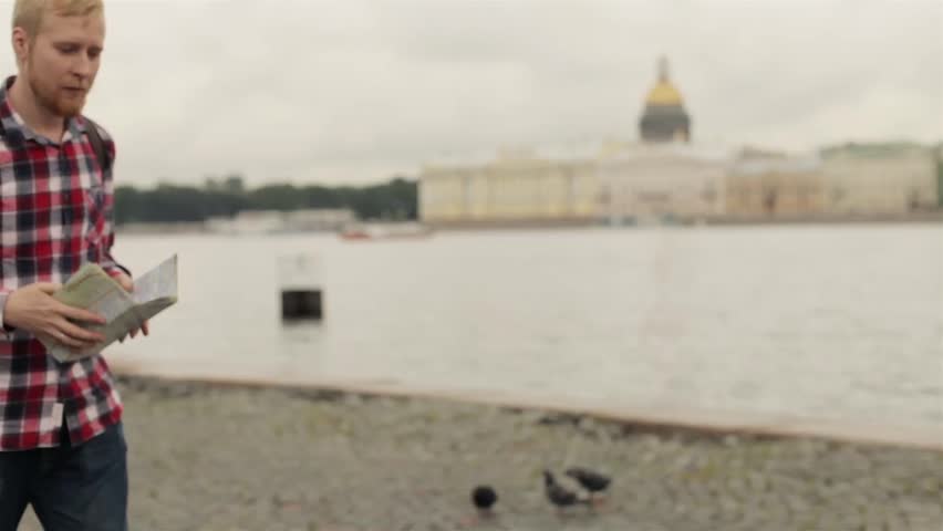 Travelling Man With Map Walking Along the Waterfront of St. Petersburg