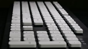 Ungraded: Hands on Keyboard / Typing on Computer / Keyboard Keys. User types a text using english keyboard against black background. (av27593u)