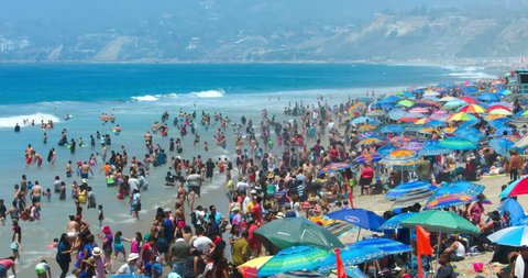 LOS ANGELES, CALIFORNIA, USA - JULY 26, 2016: Crowd of people swim in the Pacific Ocean in Santa Monica Beach on July 26, 2016 in Los Angeles, California, 4K, from RAW file, EDITORIAL