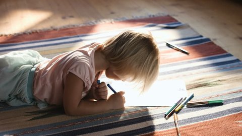 Cute little girl on the floor thinking on a drawing concept