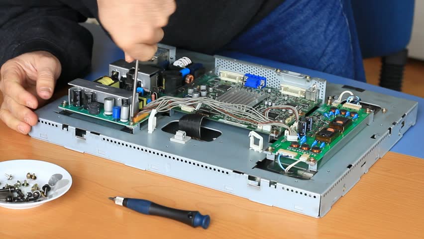 Technician fixes circuit board screws at a repair service shop 