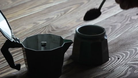 Filling Moka freshly ground coffee on wood table