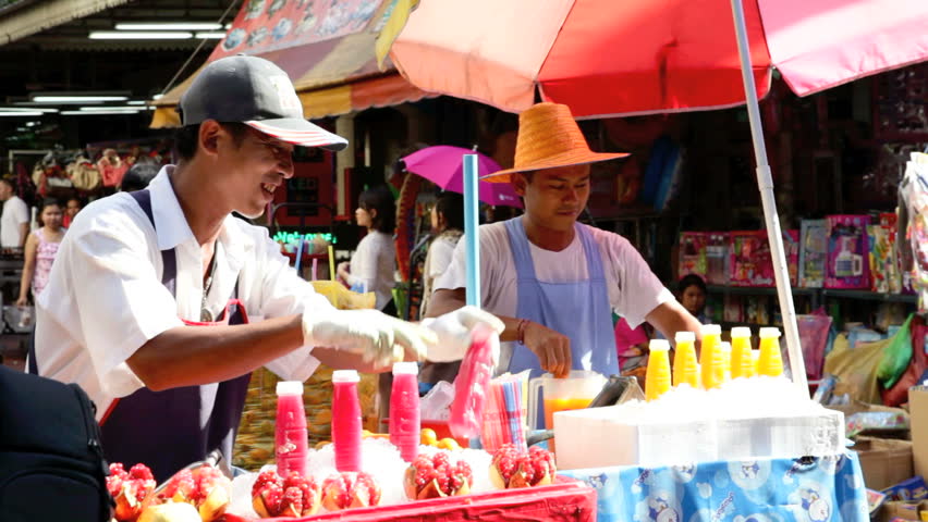 BANGKOK - DECEMBER 22: Two street vendors sell fresh fruit juice in a street of