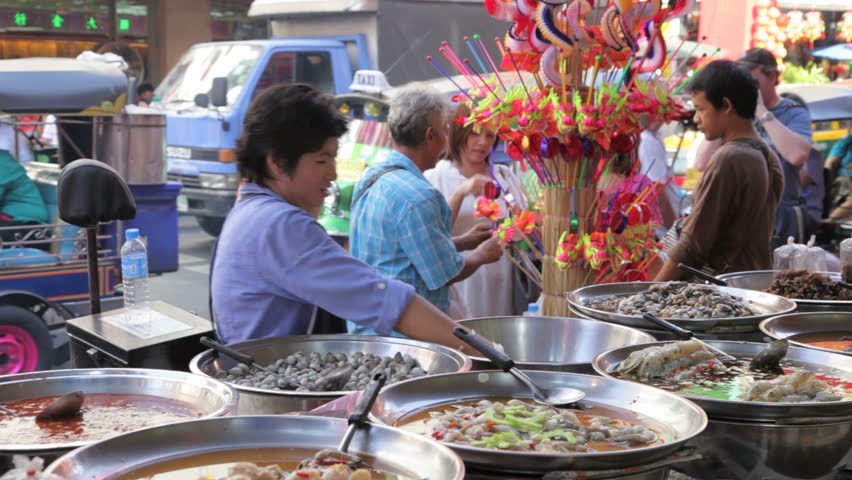 BANGKOK - DECEMBER 22: A street vendor sells food in a street of Chinatown on