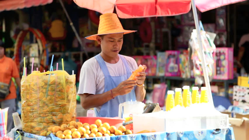 BANGKOK - DECEMBER 22: A street vendor sells fresh fruit juice in a street of