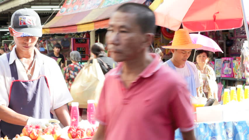 BANGKOK - DECEMBER 22: A street vendor sells fresh fruit juice in a crowded
