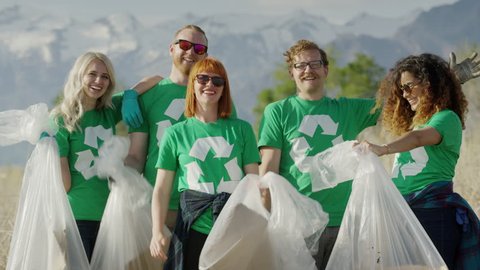 Wide tilt up shot of proud volunteers posing with garbage at beach / Vineyard, Utah, United States